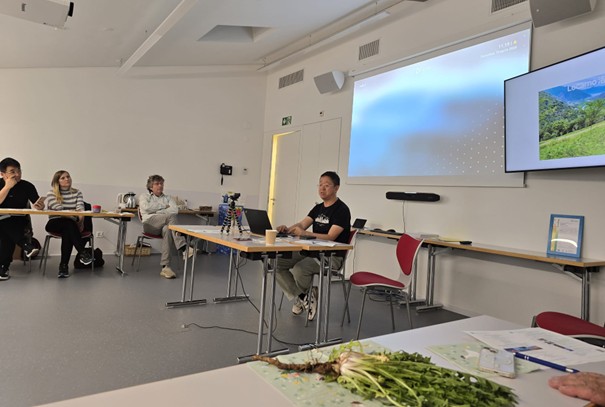 Experts and attendees follow presentations on organic herbal tea and TCM integration